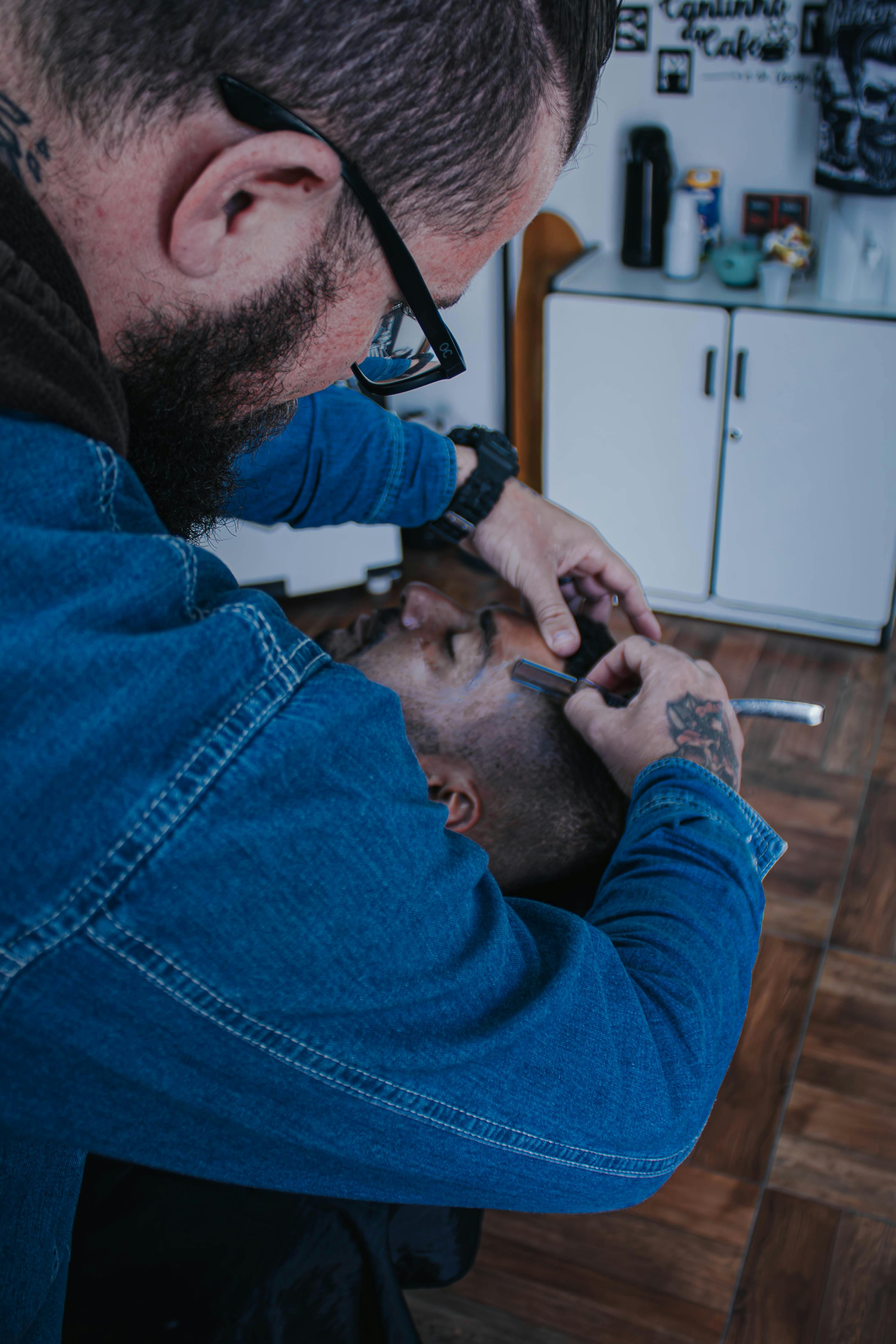 A man getting his hair cut by another man