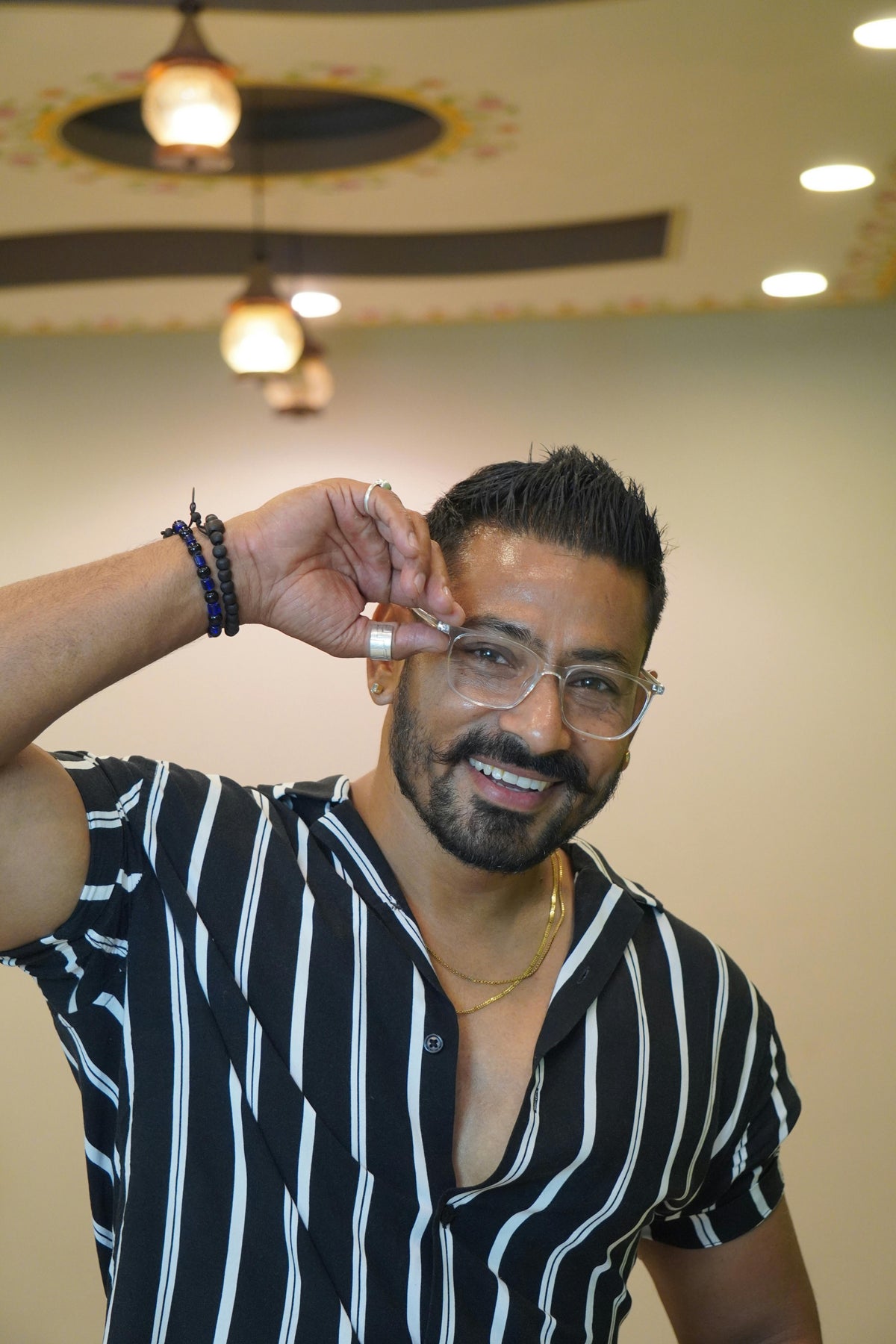 A man in a striped shirt and glasses smiling