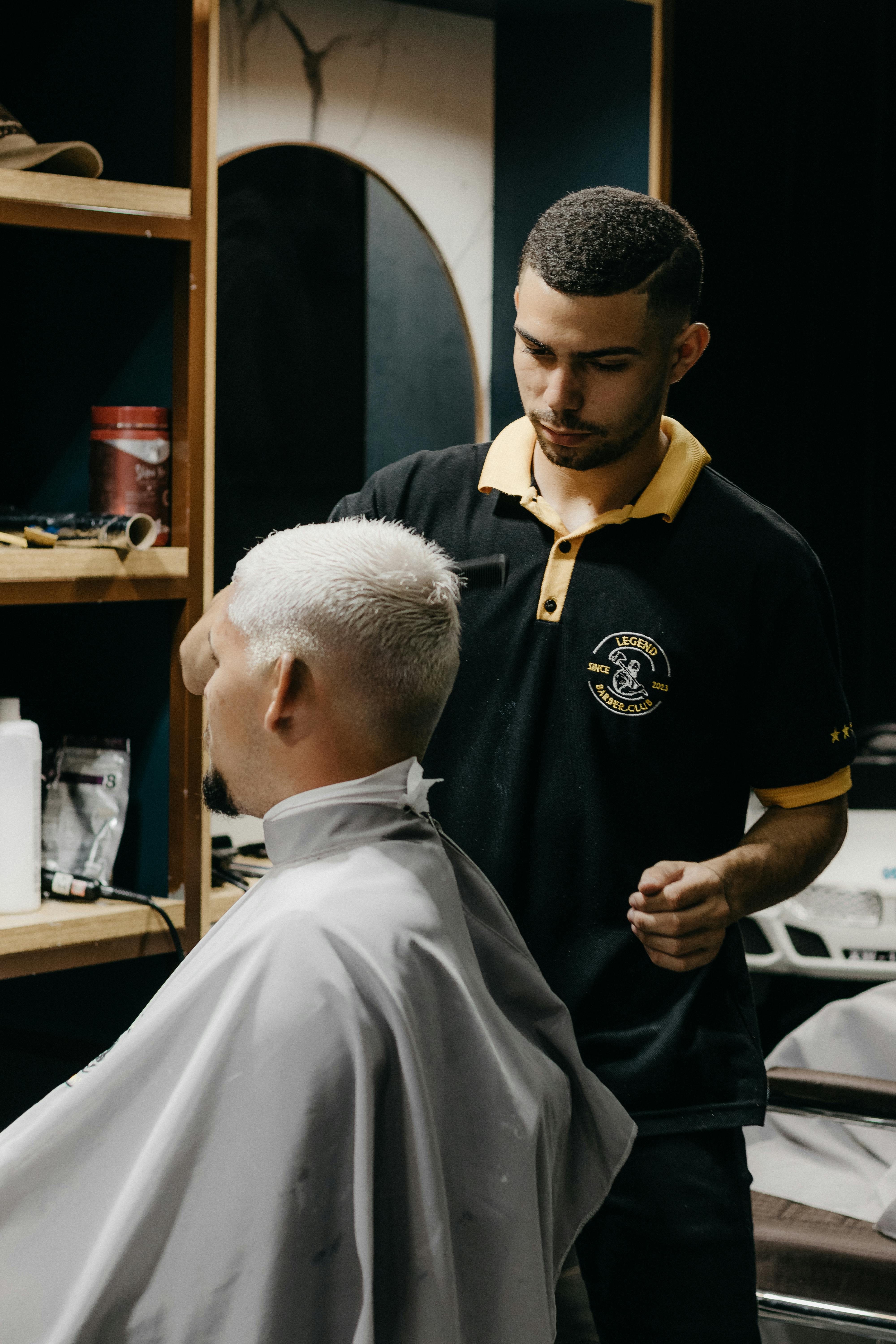 A man getting his hair cut by another man